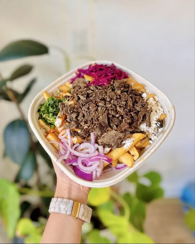 A beef shawarma bowl held up by the window