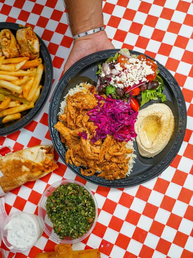 Chicken shawarma plate with hummus, feta salad and pickled cabbage, with tabbouleh and fries on the side
