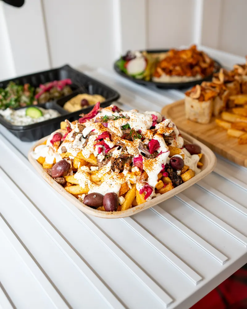 Loaded fries, a mezze tray and shawarma bites on the counter