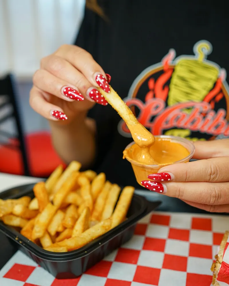 Dipping fries into Habibi sauce
