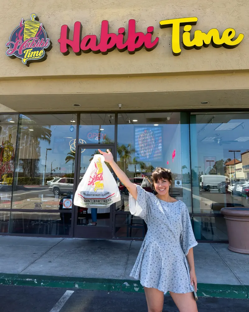 A guest holding a Habibi Time bag outside the storefront