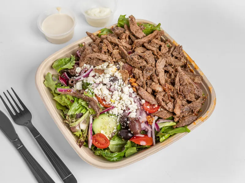 Beef shawarma protein bowl over Mediterranean salad with feta