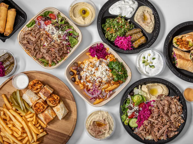 A spread of Habibi Time plates, bowls, shawarma bites, wraps and dips, seen from above